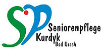 Logo der Seniorenpflege Kurdyk Bad Urach mit stilisierten grünen und blauen Buchstaben, die eine Herzform mit einem roten Punkt bilden, und dem Firmennamen in schwarzer Schrift.